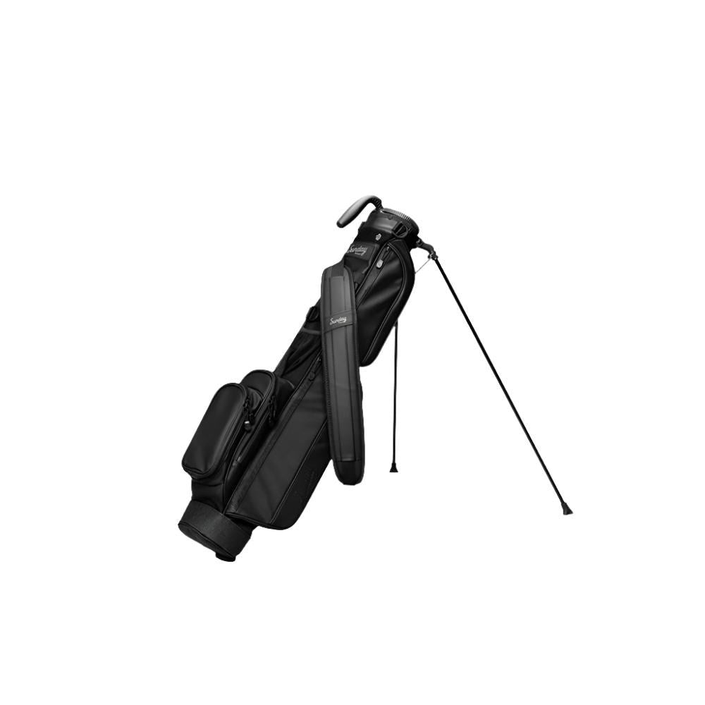 A black golf bag with a stand mechanism deployed, featuring multiple pockets and a shoulder strap.