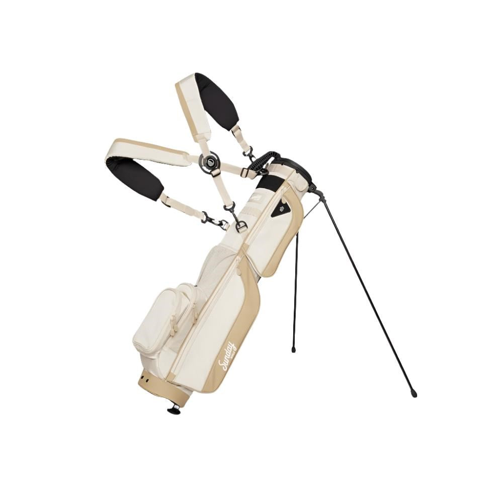 A beige and white golf bag with a stand system deployed, featuring multiple pockets and a logo on the front.