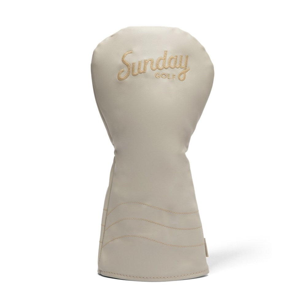 A beige golf driver headcover with the text 'Sunday Golf' embroidered in a golden script.