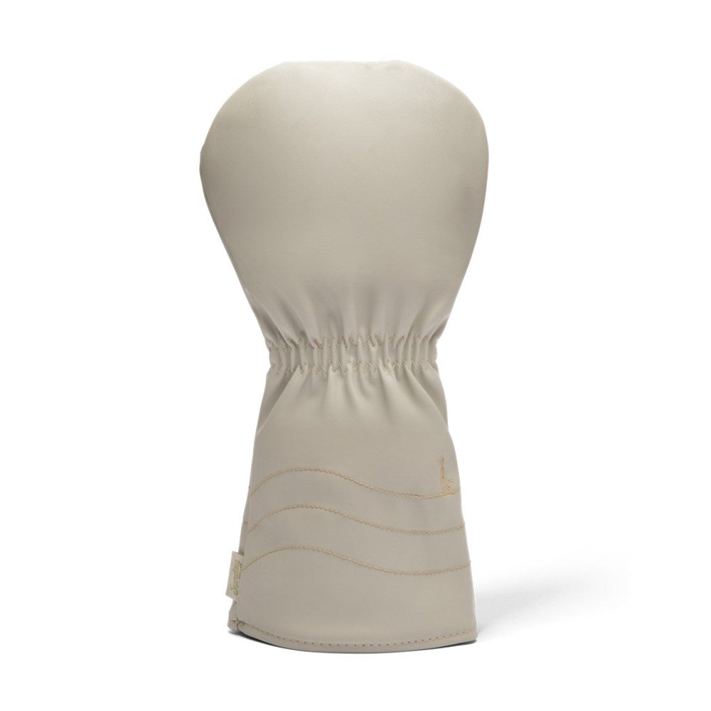 A beige golf driver headcover with the text 'Sunday Golf' embroidered in a golden script.