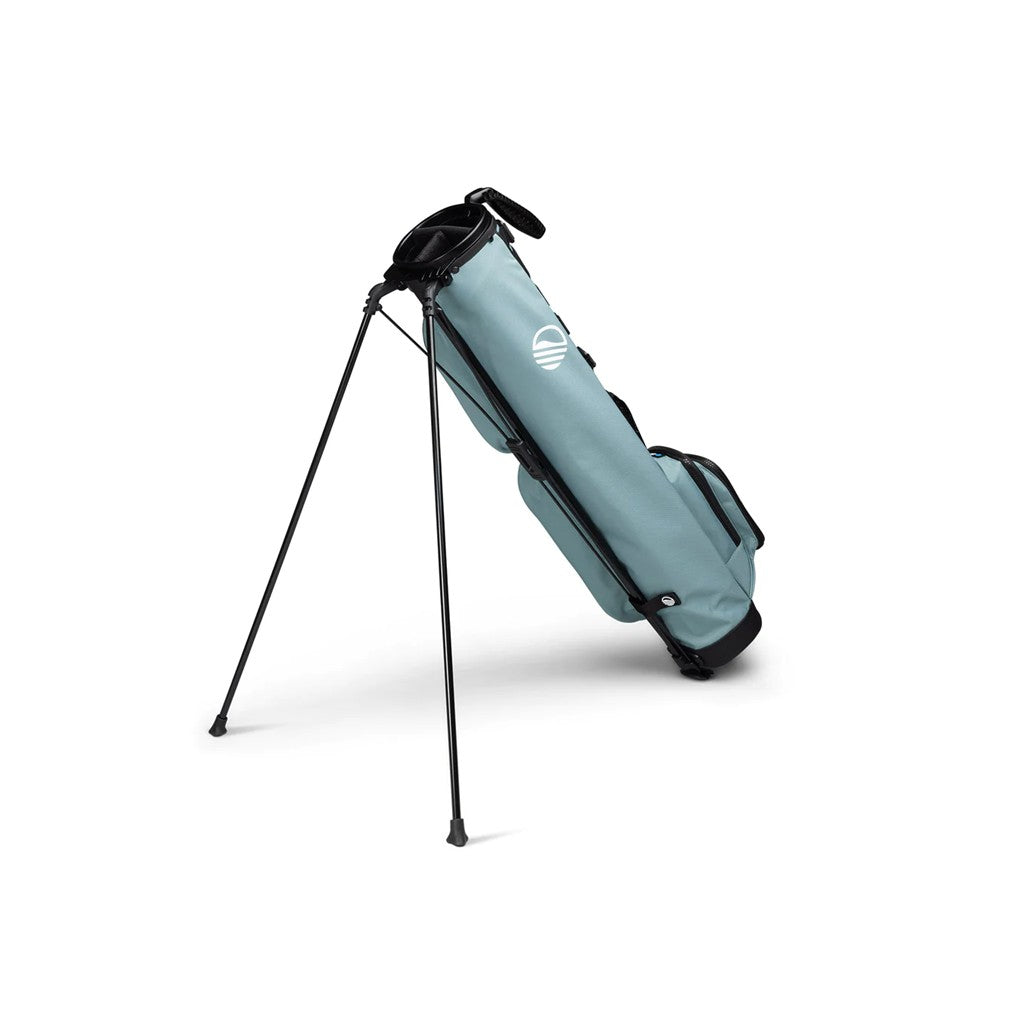 A light blue and black golf bag with a stand system deployed, featuring multiple pockets and a shoulder strap.