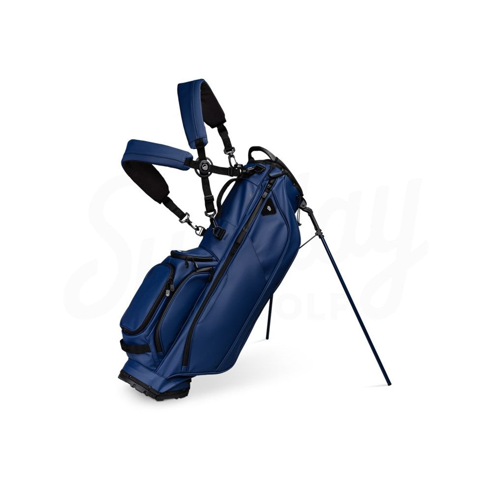 A navy blue golf bag with a stand, multiple pockets, and a backpack-style strap system.