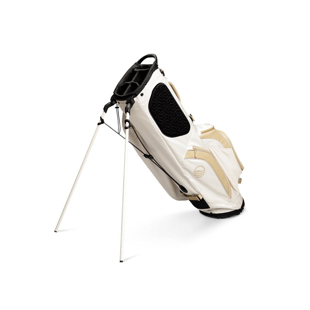A full-size stand golf bag in beige and white, featuring multiple pockets, a built-in carry handle, and a backpack-style strap system unfolded.