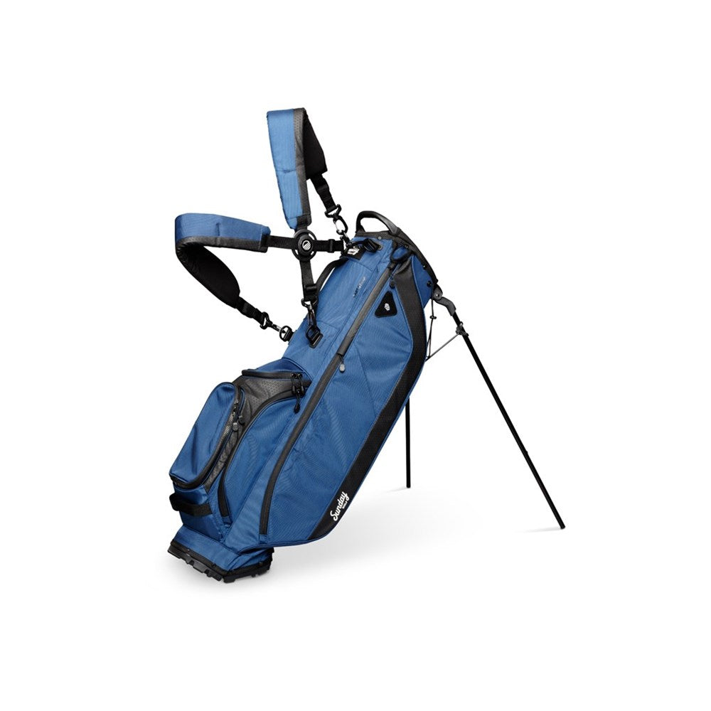 A full-size blue and black Sunday Golf stand bag with multiple pockets, a built-in carry handle, and backpack-style strap system.
