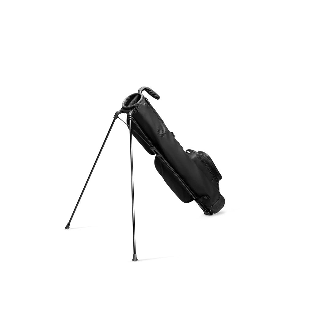 A black golf bag with a stand mechanism deployed, featuring multiple pockets and a shoulder strap.