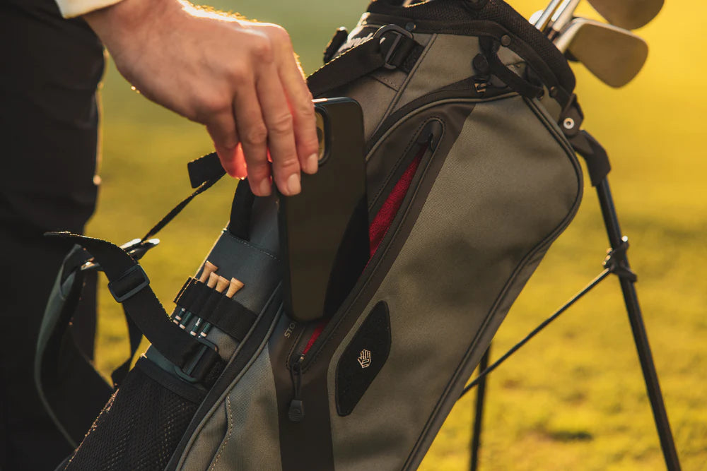 A gray Sunday Golf stand bag designed for golfers, featuring multiple pockets for phone holder.