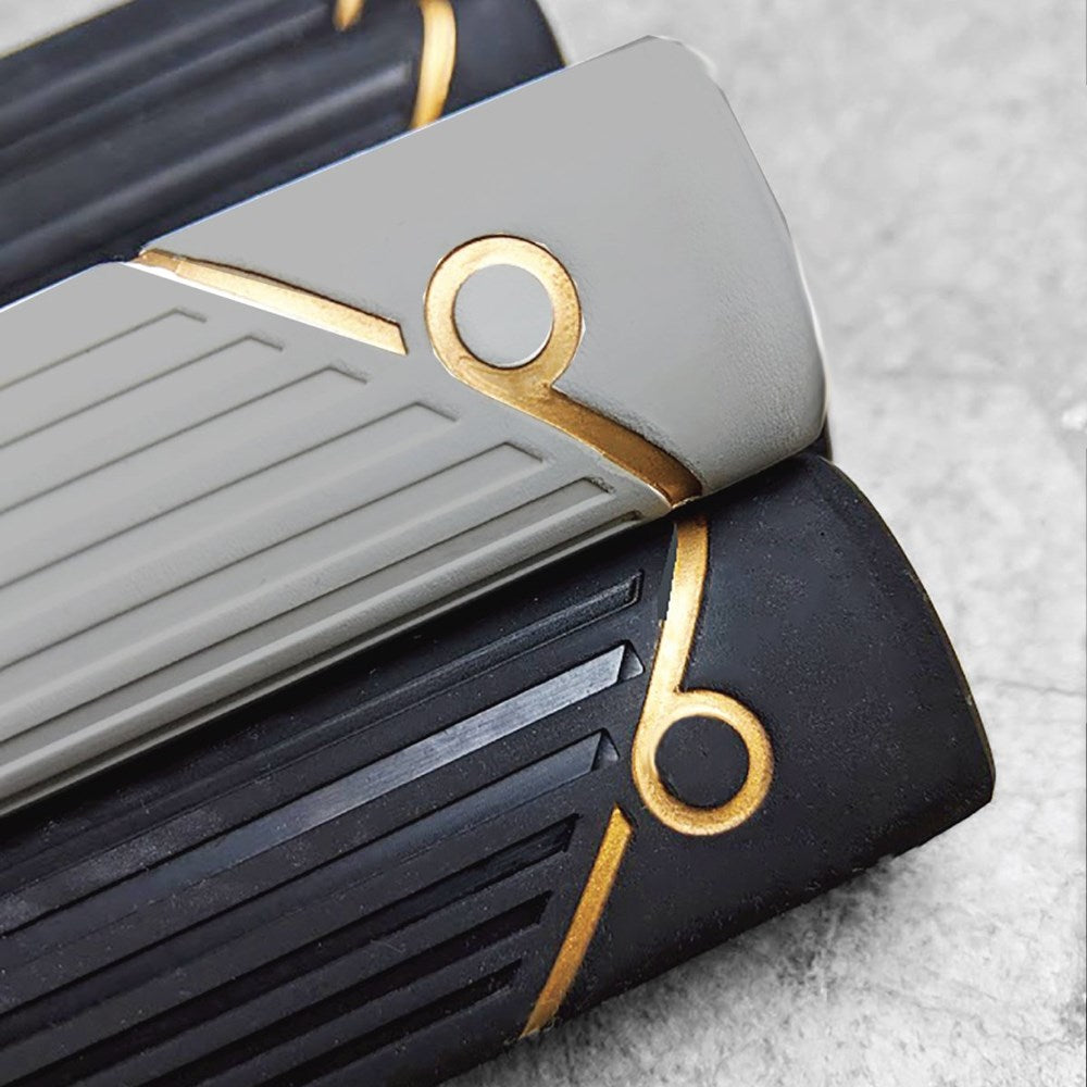 A close-up view of a putter grip with a gray and black color scheme and gold accents.