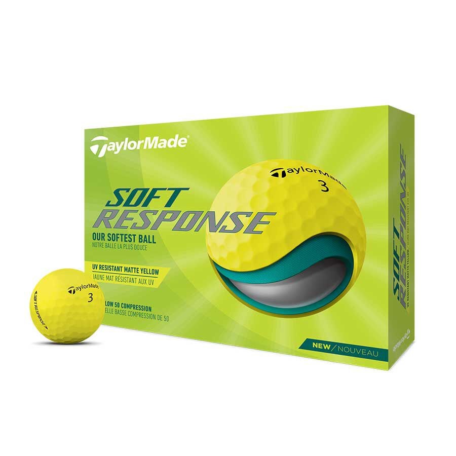 Packaging box of TaylorMade Soft Response golf ball with one golf ball visible in front of the box. The box is predominantly green with images of the golf ball and text detailing the product features.